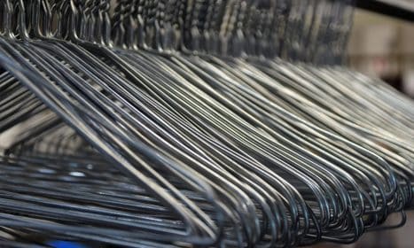 Close-up of metal clothes hangers organized in a closet, highlighting the simplicity and utility of storage solutions.
