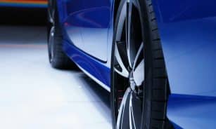 Close-up shot of a blue car highlighting the stylish alloy wheel. Perfect for automotive enthusiasts.