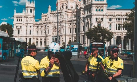 Police officers ensure security at the iconic Plaza de Cibeles in Madrid, with Cibeles Palace in the background.