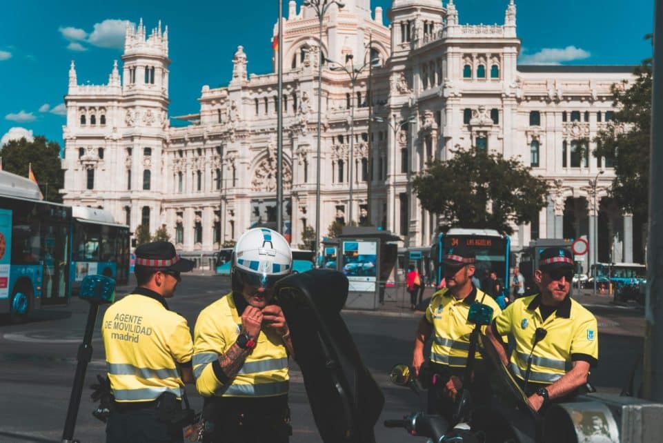 Police officers ensure security at the iconic Plaza de Cibeles in Madrid, with Cibeles Palace in the background.