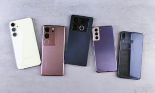 Flat lay of five modern smartphones on a gray surface, showcasing various designs.