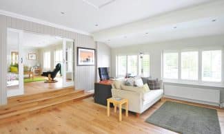 Spacious and bright modern living room with wooden floors and stylish furniture.