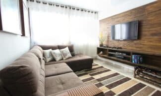 Stylish modern living room featuring a brown sofa, wall-mounted TV, and interior decor.