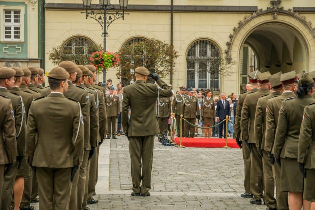 A formal military ceremony featuring Polish soldiers in uniform in Wrocław's historic square.