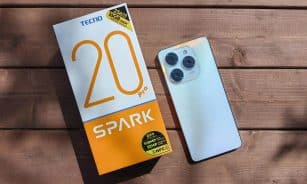 TECNO Spark 20 Pro with packaging on a wooden surface in natural light.