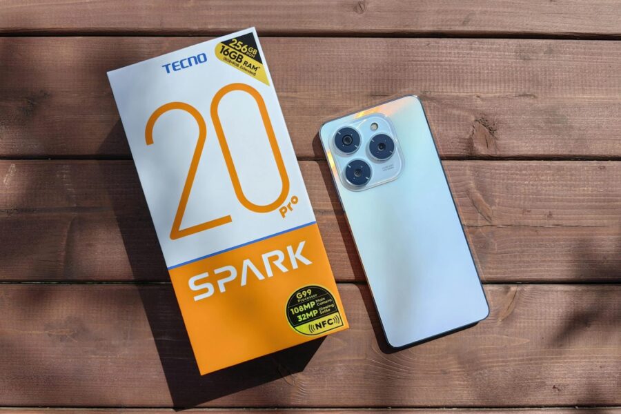 TECNO Spark 20 Pro with packaging on a wooden surface in natural light.