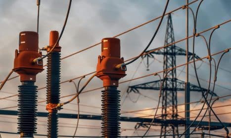 Detailed view of power transformers and lines against a sunset sky in Austria.