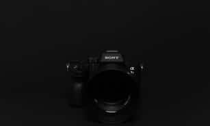 Minimalist image of a black Sony camera against a black background, perfect for tech themes.