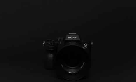 Minimalist image of a black Sony camera against a black background, perfect for tech themes.