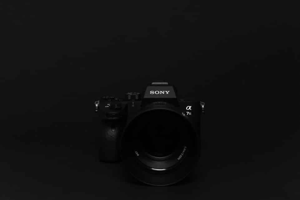 Minimalist image of a black Sony camera against a black background, perfect for tech themes.
