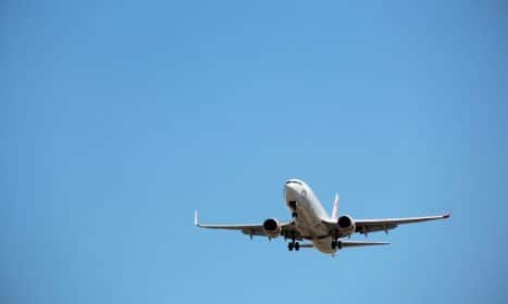 Virgin Australia aircraft captured mid-landing against a clear blue sky at Melbourne Airport.