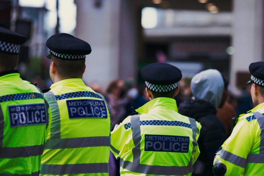 Metropolitan Police officers in high-visibility jackets on patrol in London.