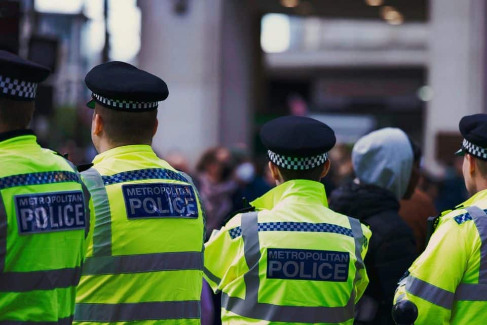 Metropolitan Police officers in high-visibility jackets on patrol in London.