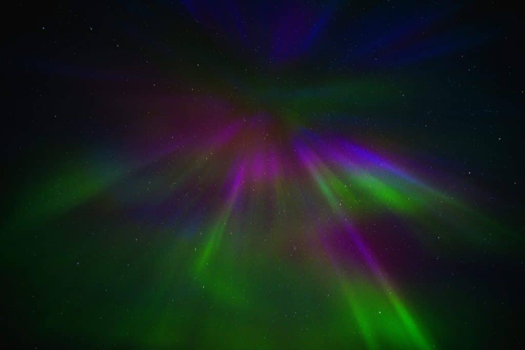 Vibrant aurora borealis spectacle in night sky showcases colorful light patterns.