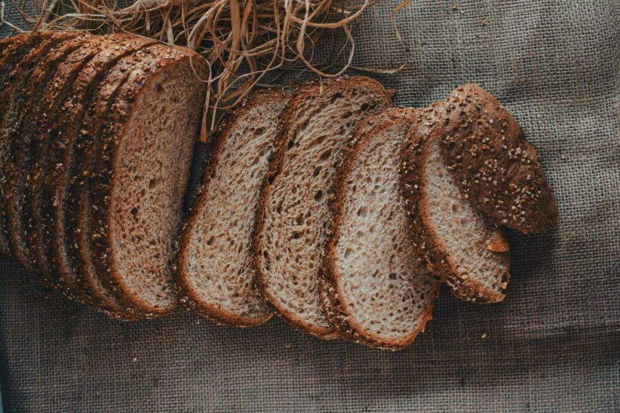 Sliced whole wheat bread arranged on burlap, showcasing crunchy texture and rustic appeal.