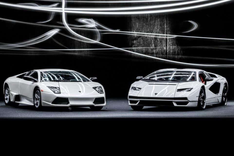 Elegant white Lamborghini Murcielago and Countach showcased with dynamic studio lighting.