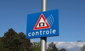 A blue road sign with a camera icon and 'controle' text indicates speed monitoring.