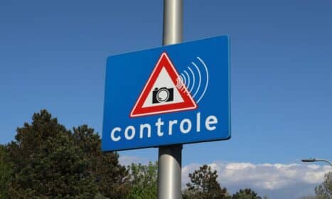 A blue road sign with a camera icon and 'controle' text indicates speed monitoring.