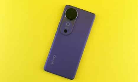 Stylish purple smartphone placed on a vibrant yellow backdrop, showcasing modern design.