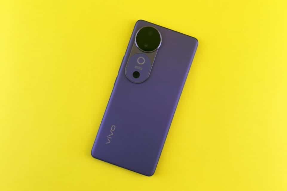 Stylish purple smartphone placed on a vibrant yellow backdrop, showcasing modern design.