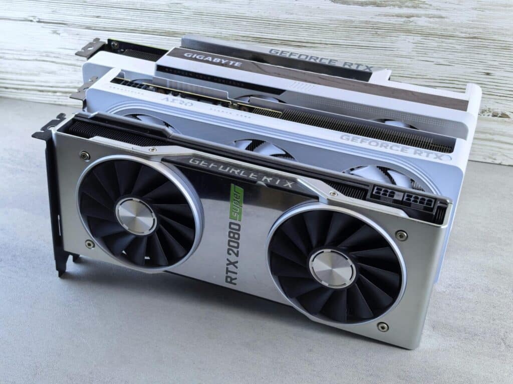 Three NVIDIA GeForce RTX graphics cards stacked on a surface, showcasing their sleek design and branding details.