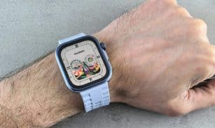 A detailed view of a Huawei smartwatch with a colorful display, worn on a human wrist.