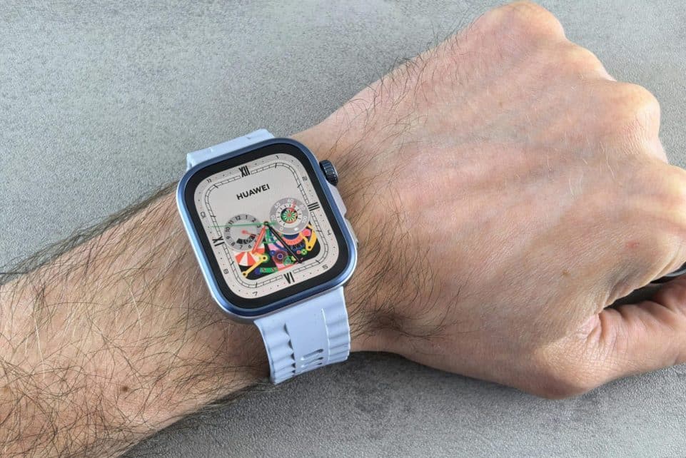 A detailed view of a Huawei smartwatch with a colorful display, worn on a human wrist.