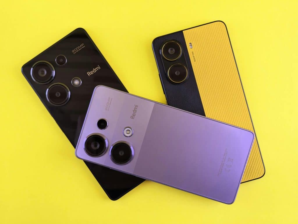 Three modern smartphones arranged creatively on a vivid yellow backdrop, showcasing sleek design and colors.