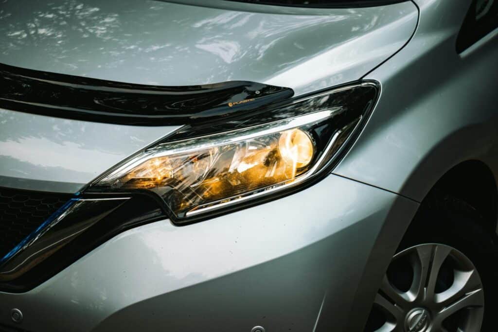 Detailed view of a car headlight showcasing modern design and reflection features.