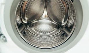 Detailed view of a clean, modern washing machine drum, showcasing shiny stainless steel interior.