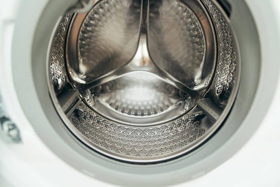 Detailed view of a clean, modern washing machine drum, showcasing shiny stainless steel interior.