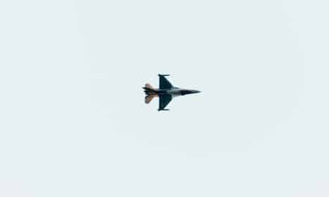 High-altitude jet fighter performing aerial maneuvers against a clear sky backdrop.