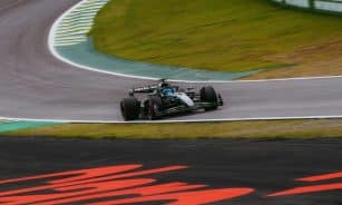 Dynamic shot of a Formula 1 car speeding around the Interlagos circuit in São Paulo.