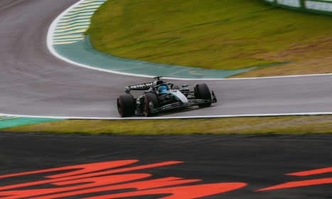 Dynamic shot of a Formula 1 car speeding around the Interlagos circuit in São Paulo.