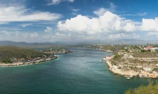 A breathtaking aerial view of Santiago de Cuba's coastal landscape under a bright blue sky.