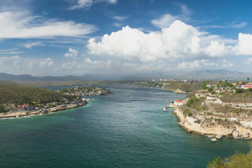 A breathtaking aerial view of Santiago de Cuba's coastal landscape under a bright blue sky.