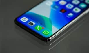 Close-up shot of a smartphone screen displaying various app icons including WhatsApp.