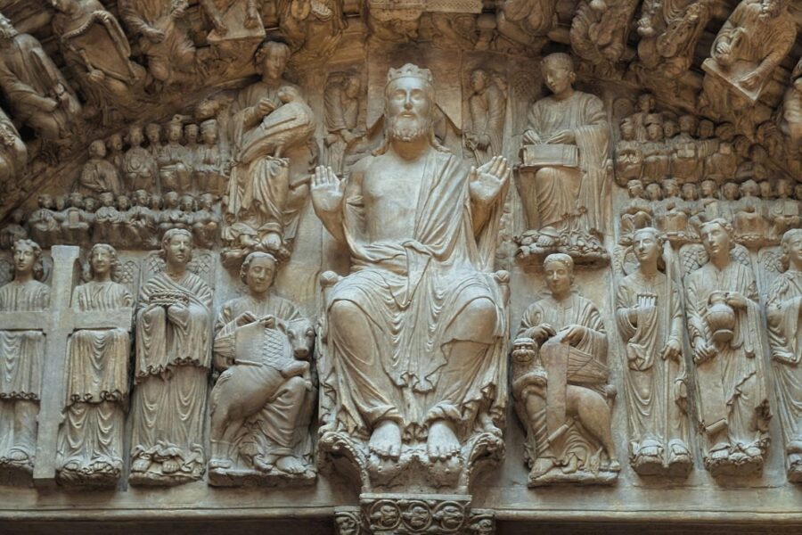 Detailed stone relief depicting religious figures and symbols at a historical site in London.