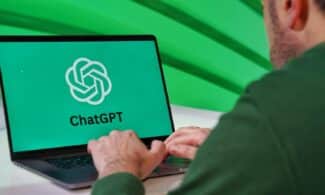 Person typing on a laptop displaying ChatGPT logo with a green vibrant setting.