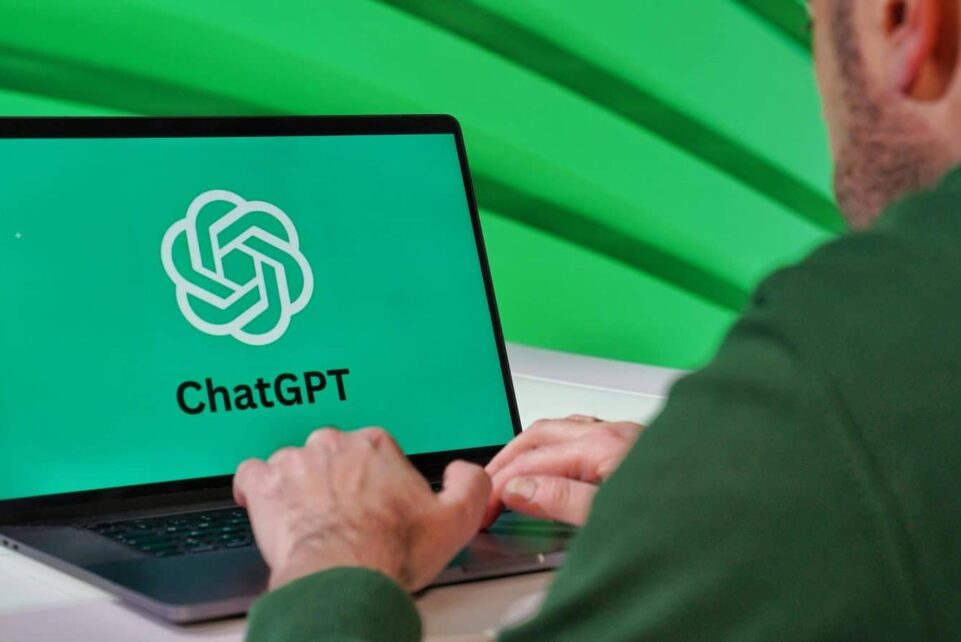 Person typing on a laptop displaying ChatGPT logo with a green vibrant setting.