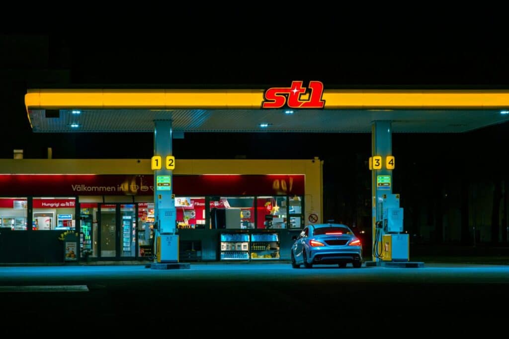 A car refuels at the illuminated St1 gas station in Jönköping, Sweden at night.