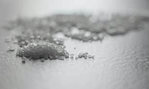 Detailed shot of coarse rock salt scattered on a textured surface.