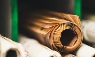 Detailed close-up of rolled brown paper on a shelf in soft focus, perfect for creative projects.