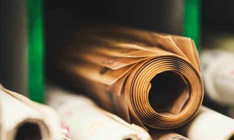 Detailed close-up of rolled brown paper on a shelf in soft focus, perfect for creative projects.