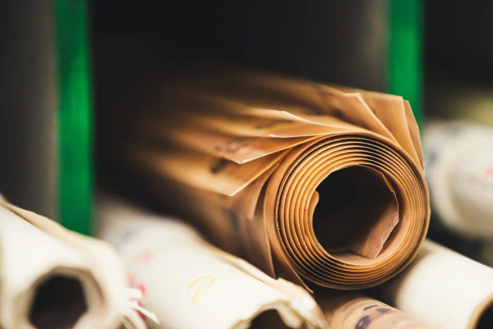Detailed close-up of rolled brown paper on a shelf in soft focus, perfect for creative projects.