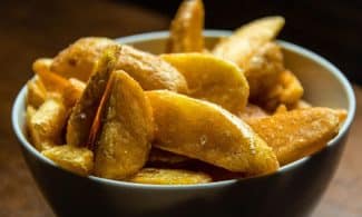 Crispy golden potato wedges seasoned and served in a bowl, perfect for snacks.