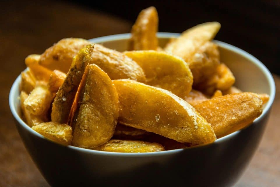 Crispy golden potato wedges seasoned and served in a bowl, perfect for snacks.