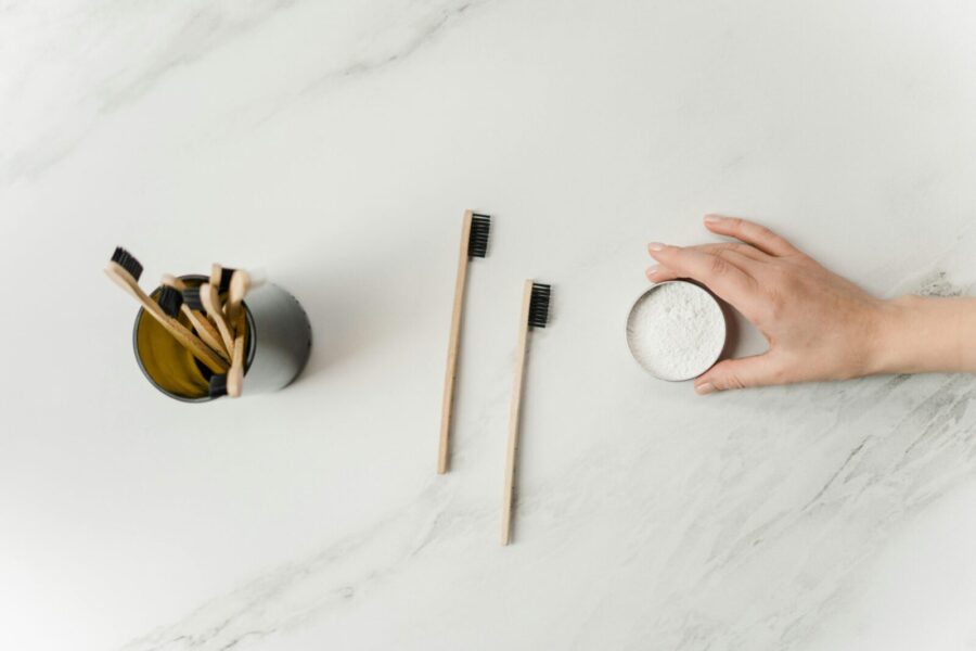 Flat lay of bamboo toothbrushes and eco-friendly dental powder emphasizing sustainable hygiene.