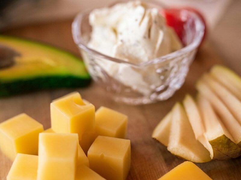 A delicious cheese platter featuring assorted cheeses, fresh fruit, and creamy cheese, ideal for a gourmet snack.