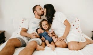 Happy family relaxing and enjoying quality time on a cozy bed, expressing love and togetherness.